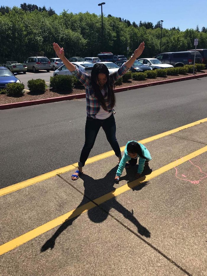 Students tracing shadow outlines with chalk on concrete