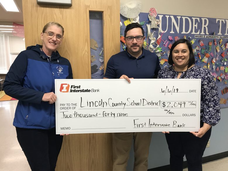 Check presented to Shelley Moore, principal of Sam Case, Trevor Brittsan of First Interstate Bank, and Kristin Becker, principal of Yaquina View